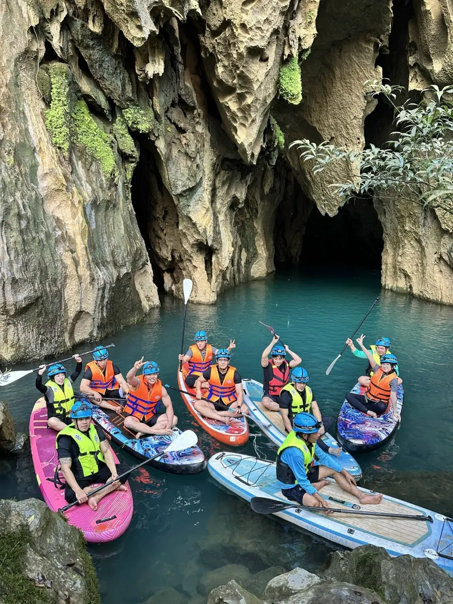 Nhóm du khách chèo kayak trên hồ nước xanh tại Hang Thủy Cung